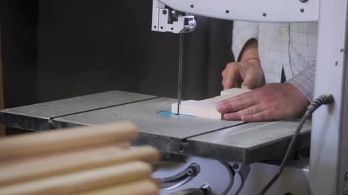 A man works with wood in a workshop. Working with wooden blanks. A man drills holes in wooden blanks