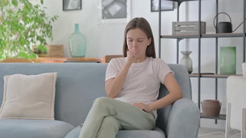 Woman Coughing on Couch Indoors During the Day