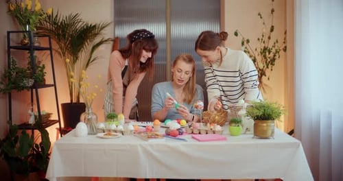Women Decorating Easter Eggs Together at Home