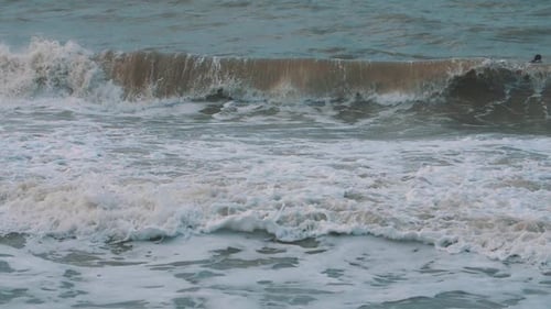 foamy waves crashing in slow motion on the beach