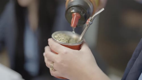 Close-up of man pouring water, preparing Yerba Mate tea, South American tradition