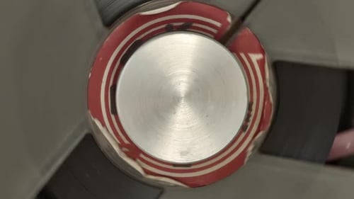 Magnetic deck in tape recorder, extreme top down closeup of spinning center
