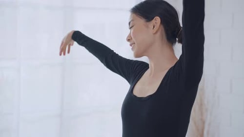 Graceful Woman Performs Arm Exercises Indoors