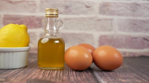 Lemons, Eggs, and Bottle of Liquid on Table