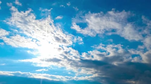 Soleil d'été éclatant avec des rayons dans le ciel bleu. Des nuages gris recouvrent rapidement l'horizon. Timelapse
.
