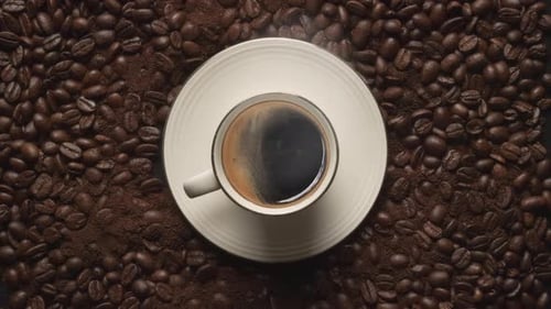 Steaming Cup of Coffee on Coffee Bean Background