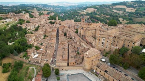 Stunning aerial shot of Urbino, Italy, showcasing its historical buildings, medieval streets, and su