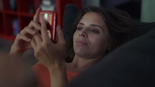 Woman Relaxing on Couch Using Mobile Phone