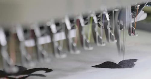 Una máquina de coser automática cose con hilos de colores y precisión a la hora de confeccionar cualquier forma o diseño.