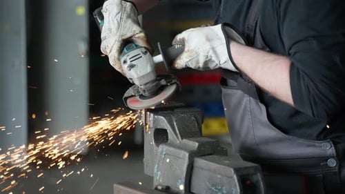 A man working with angle grinder, sparkles, super slow motion, close up