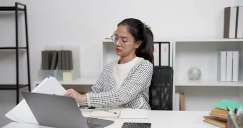Young Woman Working on Laptop in Bright Office
