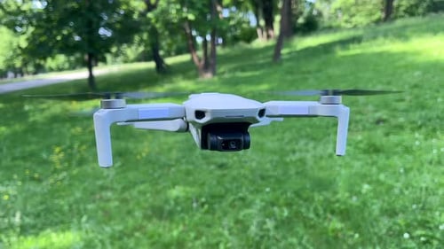 Amazing Closeup Shot of Drone Hovering in Windy Green Park Daylight