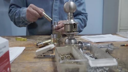 Hispanic man working in security service working on duplicate key. Repair and maintenance of locks.