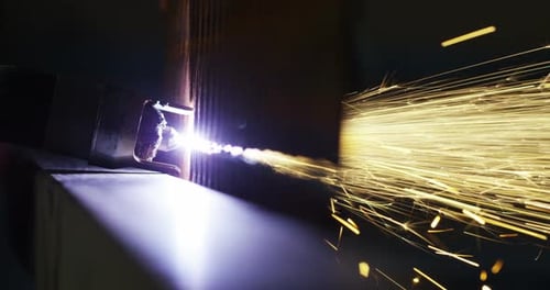 Der Schlosser schneidet mit einem Laser ein halbes Stahlblech ein, wodurch Funken entstehen. Die Laserhitze Kerbe Eisen bis zu