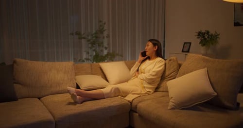 Woman Reclining on Sofa Talking on Phone Indoors