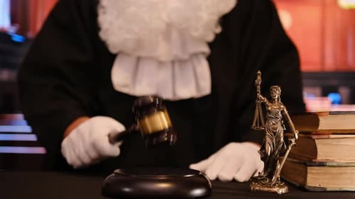 A Judge Stands in a Courtroom Gavel Poised Symbolizing the Principles of Justice and the Legal