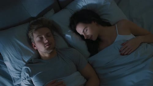 Top View Bed at Night: Attractive young Couple Sleeping Together, Holding Each other in Arms, Embr