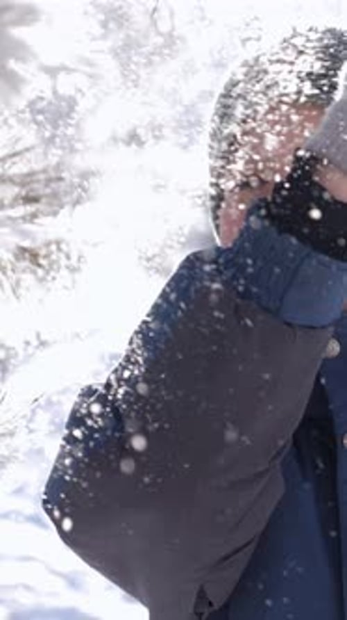 Kind spielt freudig in verschneiter Landschaft, umgeben von funkelnden Schneeflocken und Winterbäumen