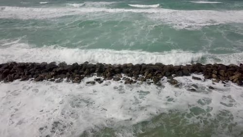 Ocean Waves Crashing Against Rock Barrier
