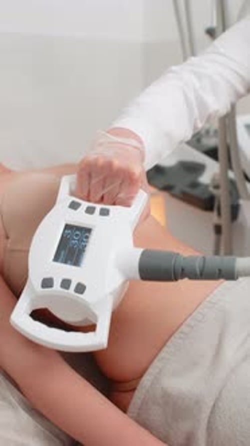 Cosmetologist Performs LPG Body Contouring Therapy on Woman Lying in Clinic During Slimming Session