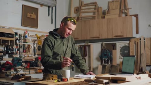 Woodworking Carpenter Thinks About a Project Over Coffee Focused Carpenter in the Workplace