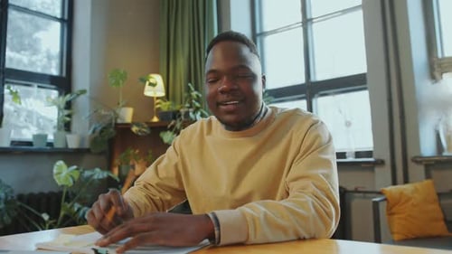 Young Adult Man Talking at a Table Indoors