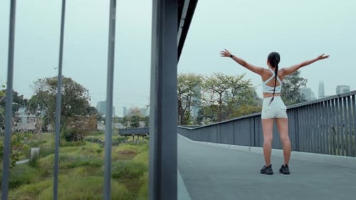 Young fitness woman in sportswear exercising in city park