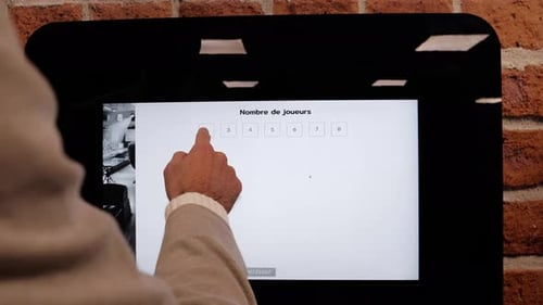 Foto em close-up de um homem usando um sistema de reserva digital para um clube de karaokê