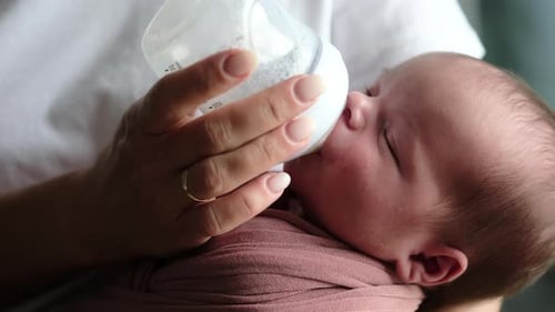 Bottle Feeding a Newborn Infant, Close Up Shot