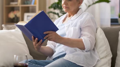 Age, Leisure and People Concept - Senior Woman Reading Book at Home Adult