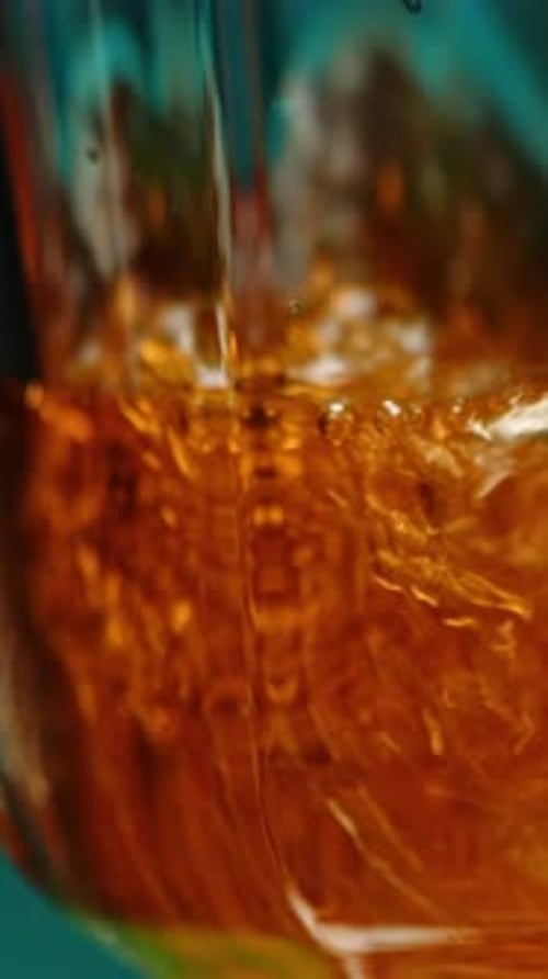Amber Liquid Being Poured into Glass Close Up