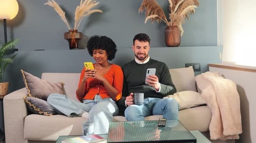 Couple Relaxing on Sofa Using Mobile Phones