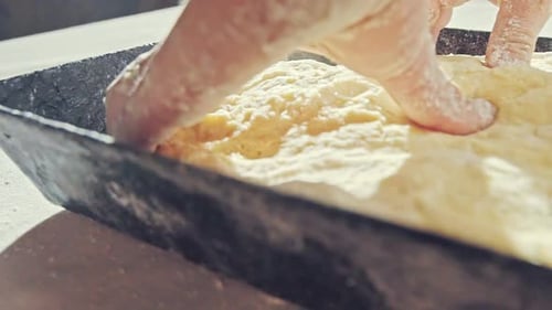 Flour Covered Hands Working Dough in Metal Pan