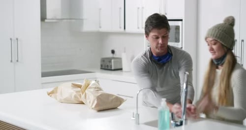 Couple Disinfect Groceries in White Modern Kitchen