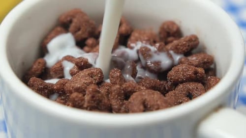 Milk Poured on Chocolate Cereal in White Bowl
