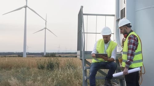 Team of Technician and Engineer Working in Wind Turbine Farm Planing Renewable Energy Ecology