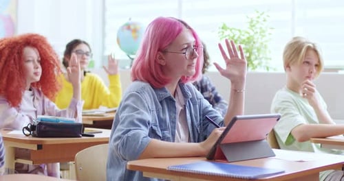 Students Raising Hands in Sunny Classroom