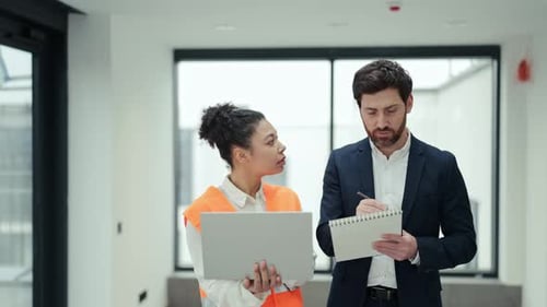 Investor And Construction Specialist Discuss Project Details Inside New Office Building