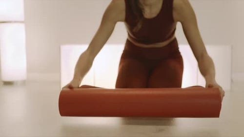 Woman Unrolling Yoga Mat Before Exercise at Home