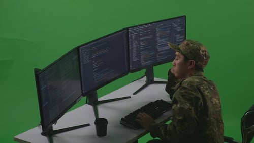 Side View Of Bored Asian Man Soldier Developer Write Code With Multiple Screens In Green Screen