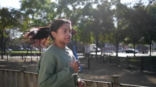 Young African American Slim Woman Runner Jogging in the Morning in Urban Park in Tracksuit Slow