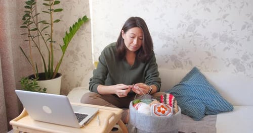 Woman Crocheting at Home in Cozy Setting