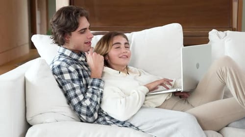 Young Couple Relaxing at Home with Laptop