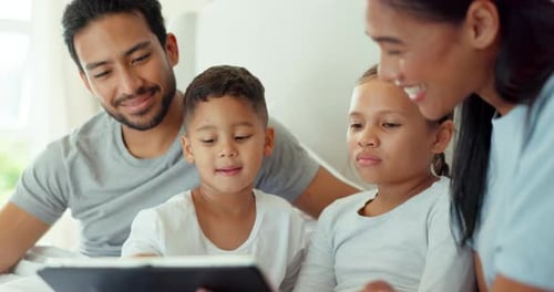 Happy Family Using Tablet in Bed at Home