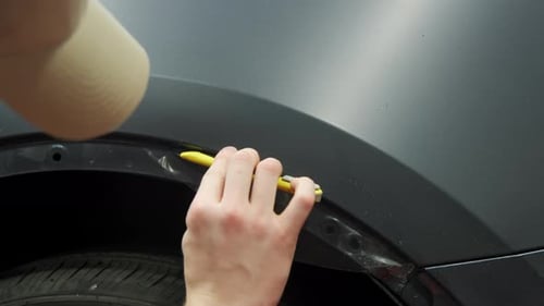 Process of Applying a Protective PPF Film to a Car Worker Applying a Protective Film on a Black