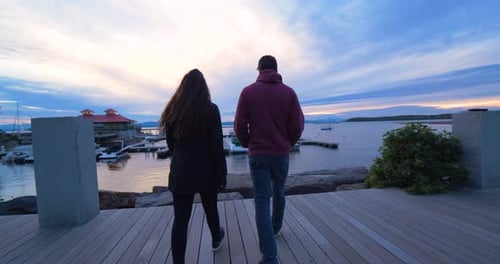 Couple Walking Dock at Sunset Boats in Harbor Anchor