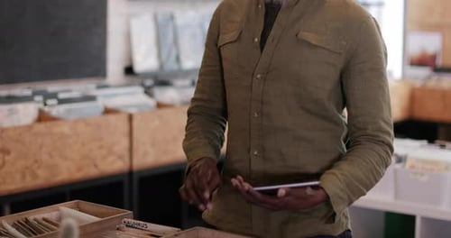 Portrait of small business owner using digital tablet in a record store