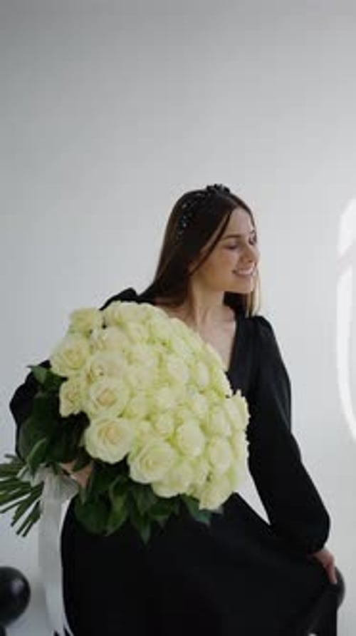 Woman Holding Roses Posing in Minimalist Room
