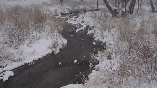 Scenic winter creek meandering through a snowy Minnesota landscape in serene nature