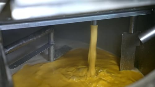 Yellow Mixture Pours into an Industrial Vat